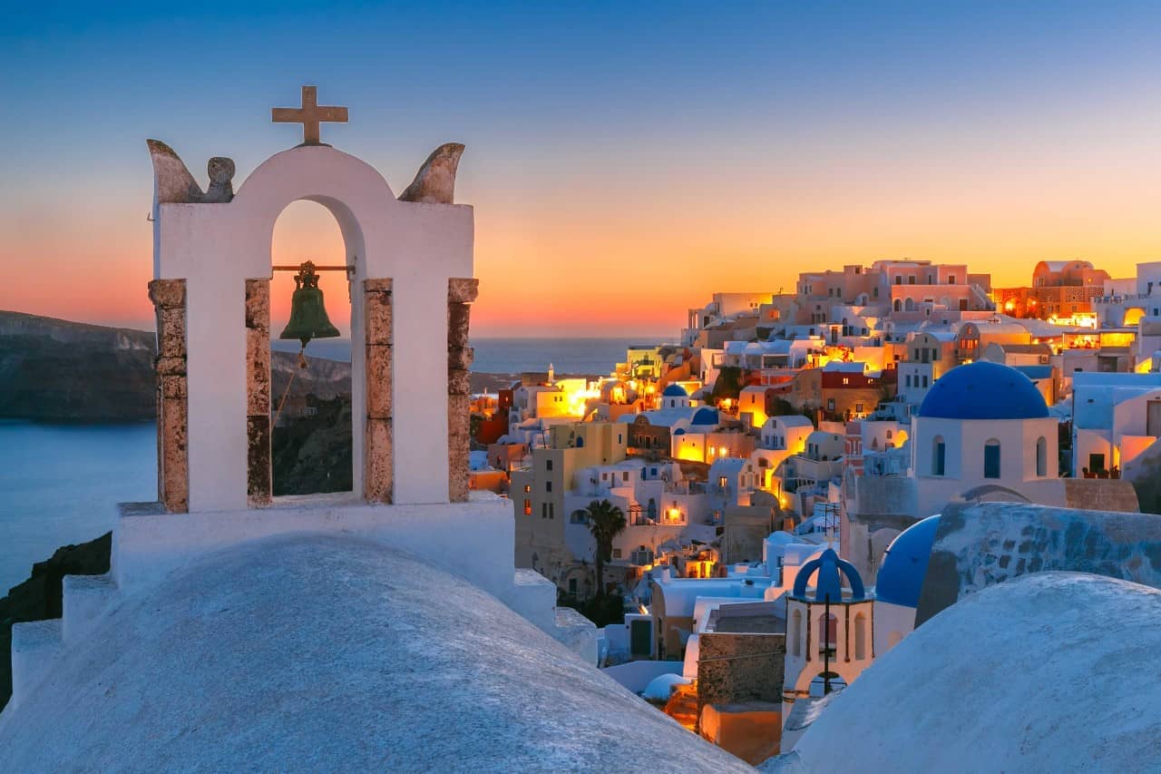 Fira village at sunset with bell tower and blue domes