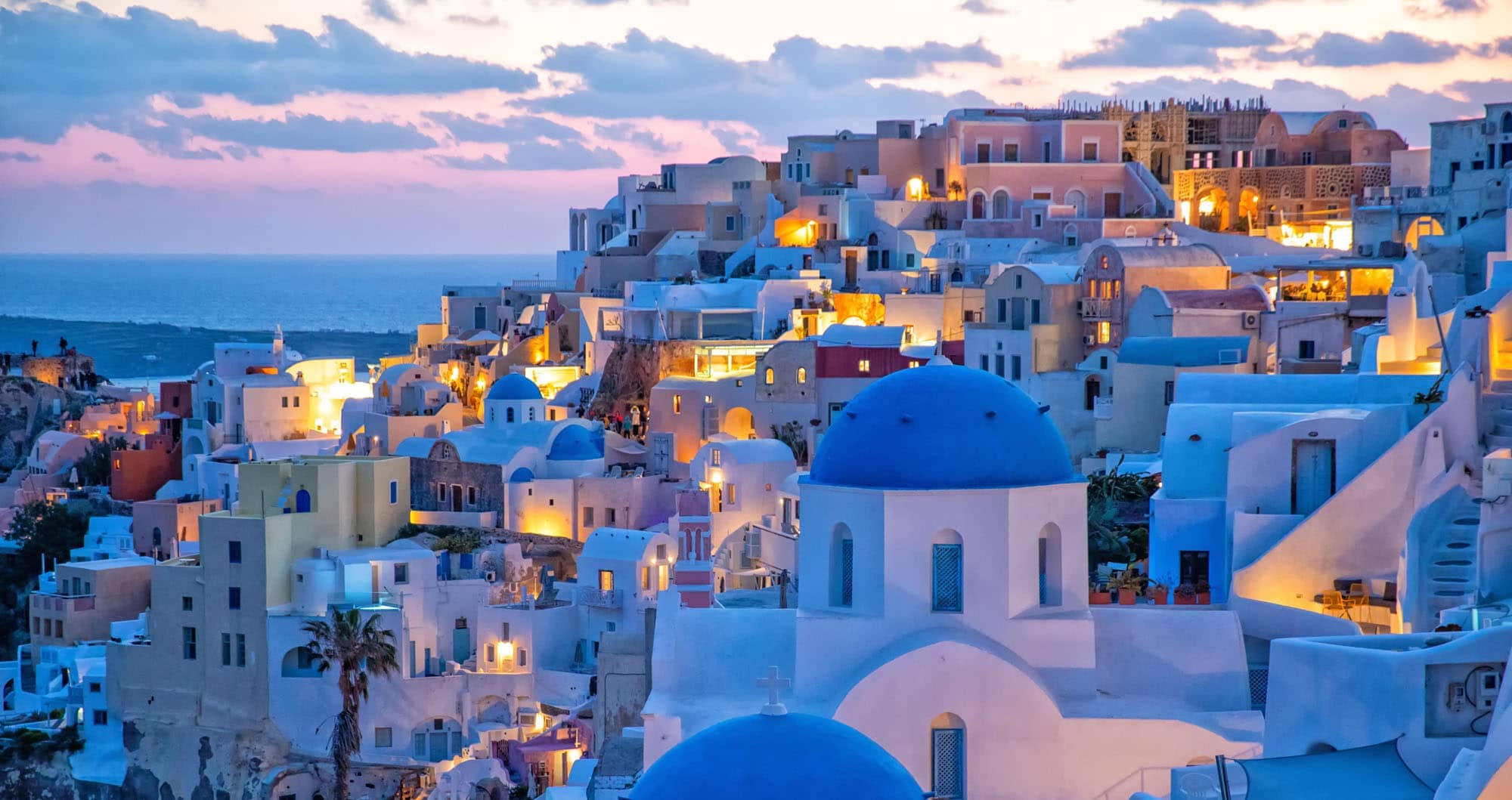 Oia village illuminated at twilight with blue domes